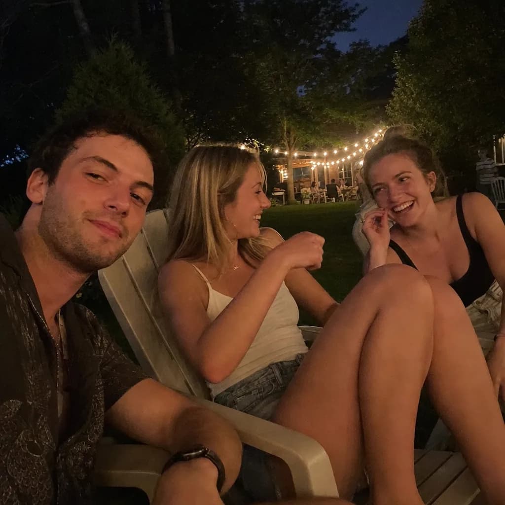 Freunde lachen im Garten bei Lichterketten